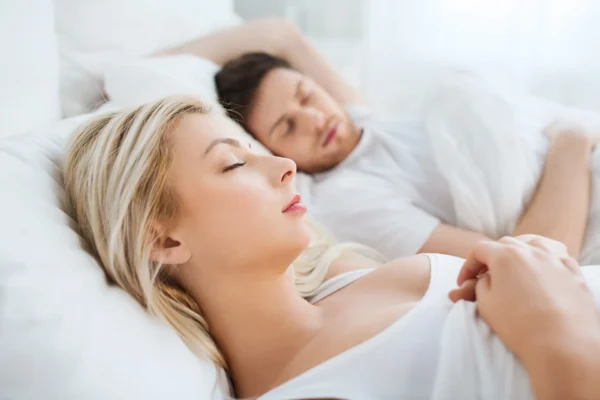 Paar schläft entspannt im Bett und verbessert die Schlafqualität